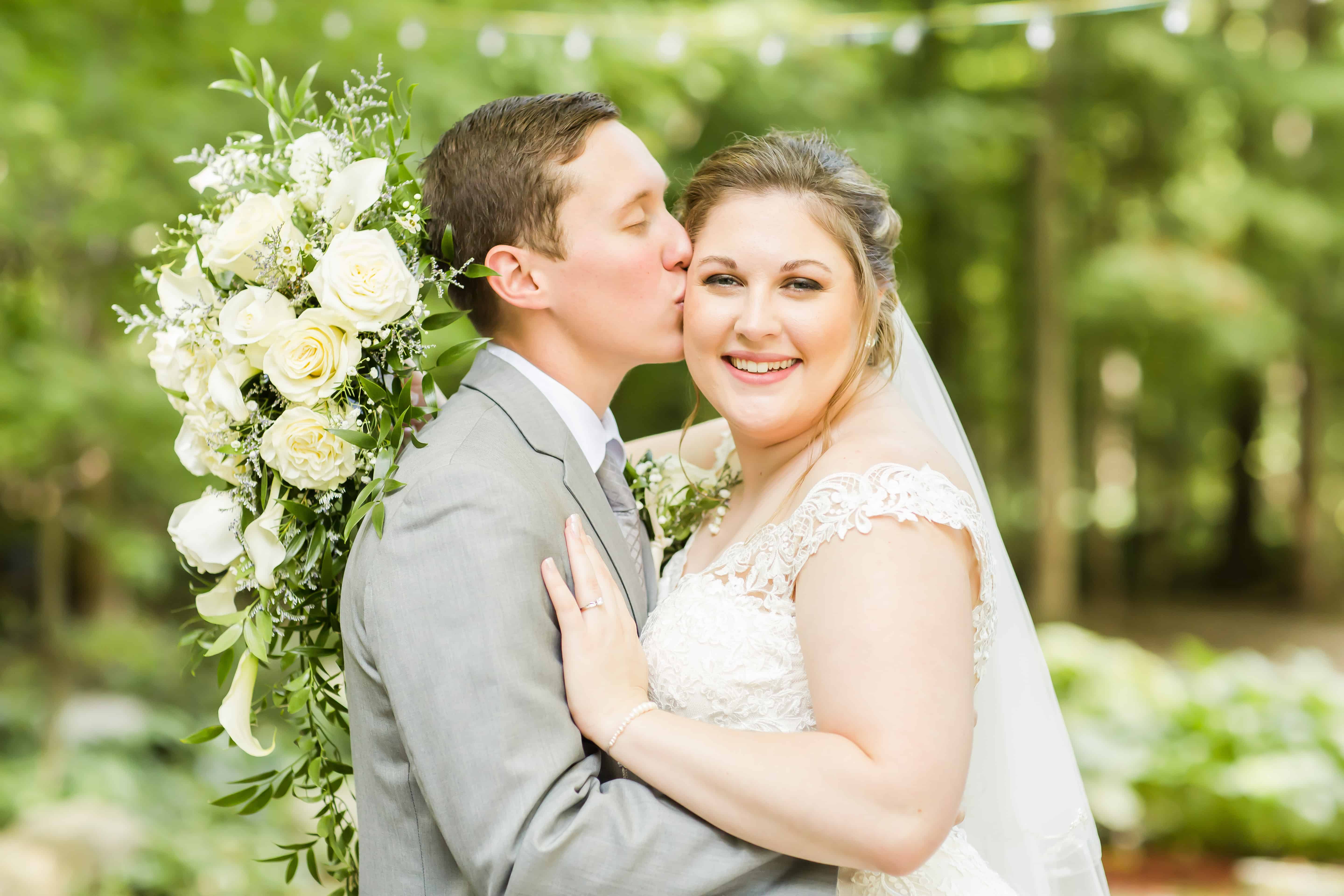 Groom kissing bride on temple at their In the Woods Wedding photographed by Akron Ohio Wedding Photographer