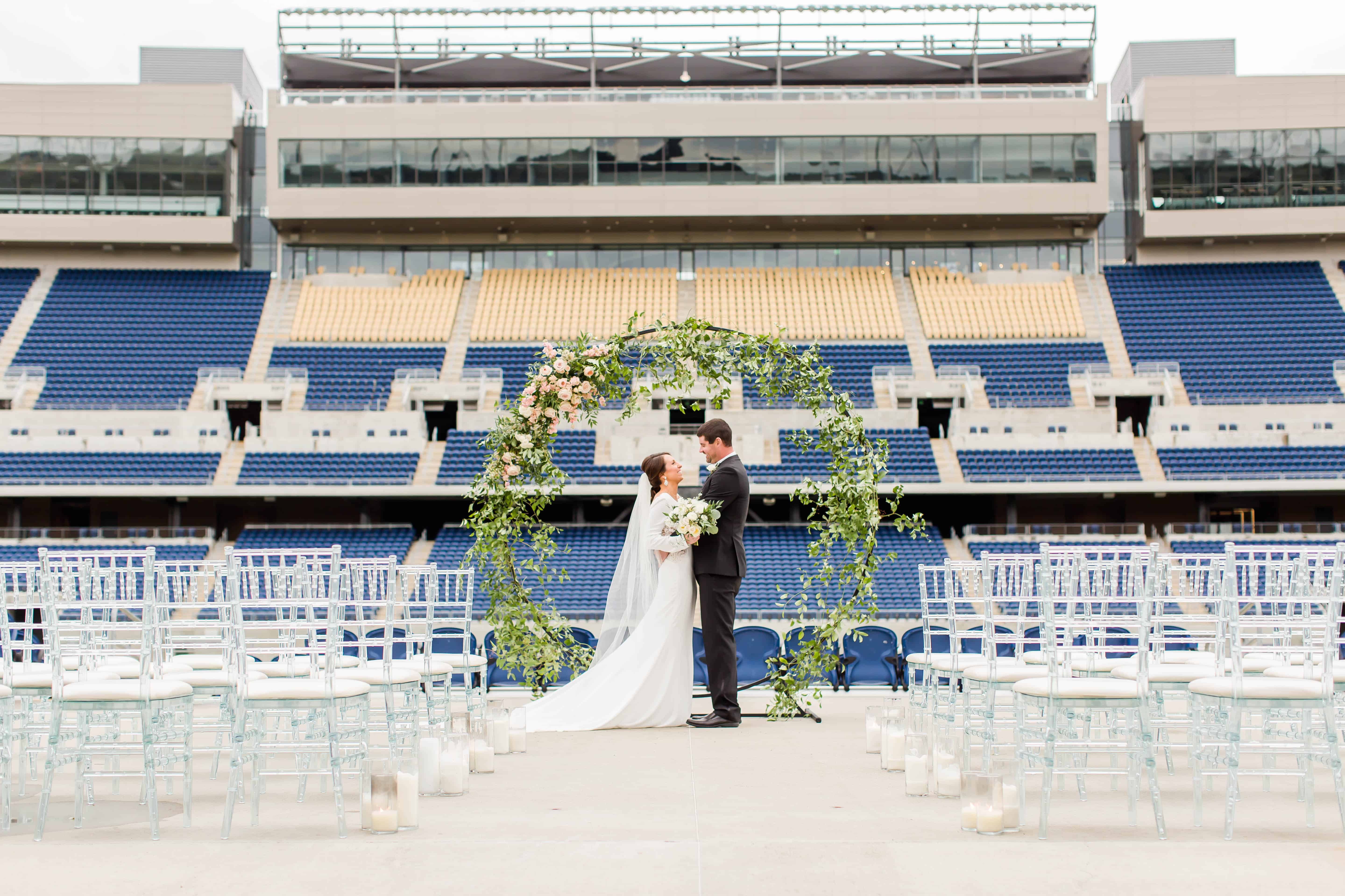 Bride and Groom standing at their ceremony site at the Tom Benson Hall of Fame Stadium photographed by Akron Ohio Wedding Photographer Loren Jackson Photography