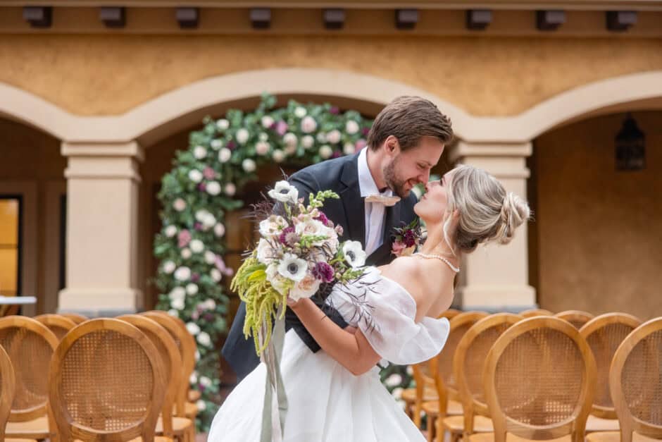 Romantic ceremony moment at Gervasi Vineyard with floral arch, designed by Savvy Jane Planning, Cleveland OH wedding planner