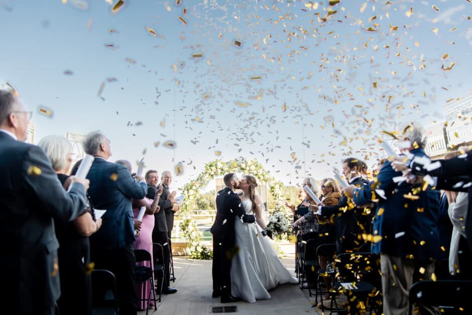 Wedding ceremony exit with confetti toss at Pro Football Hall of Fame, joyful moment captured by wedding photographer Cleveland OH with Sirpilla Soirée