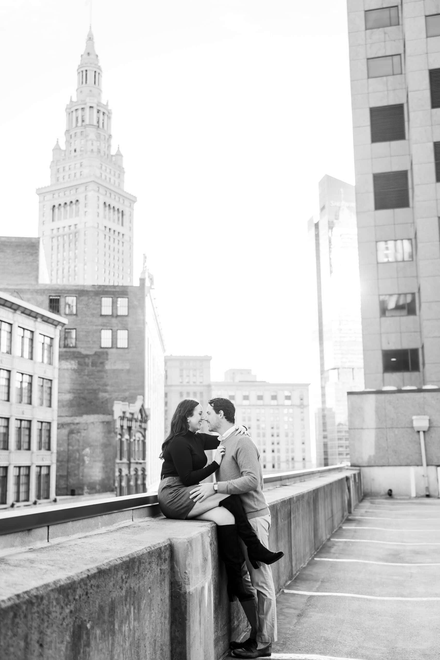 Couple kissing with the Terminal Tower behind them during a Downtown Cleveland engagement session.